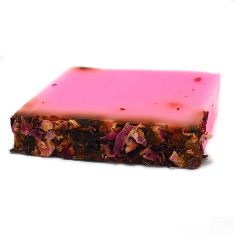 Rose soap bar with rose petals embedded, creamy texture and delicate scent.
