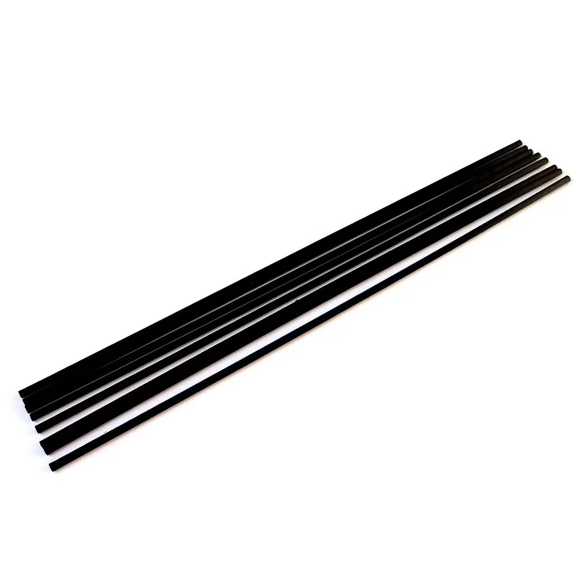 Three 25cm x 3mm fibre black home diffuser reeds standing upright on a white background