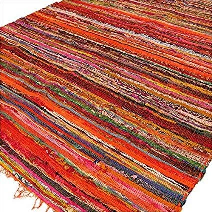 Luxury rag rug in orange measuring 152 by 90cm laid flat showing texture and vibrant color