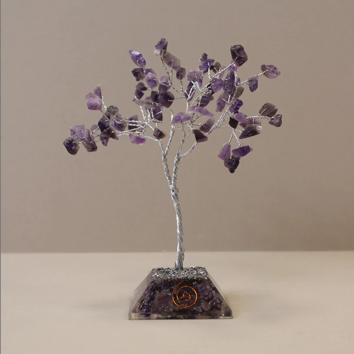 Gemstone tree with 80 amethyst stones on a decorative organite base decoration against a white background