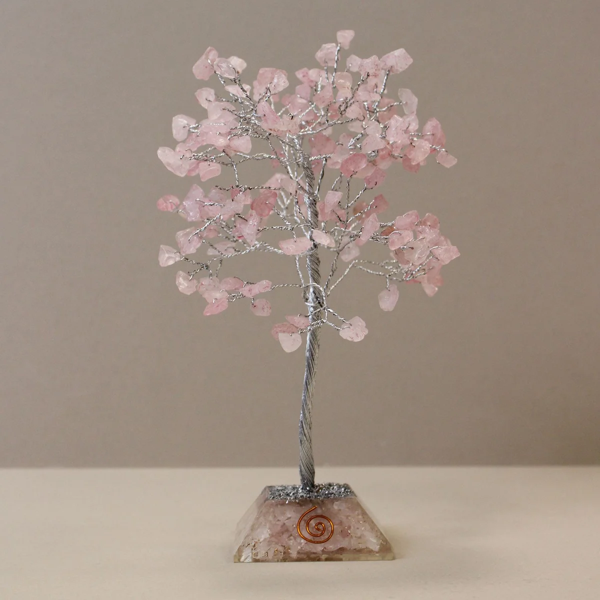 Rose quartz gemstone tree with 160 stones on an organite base displayed on a white background