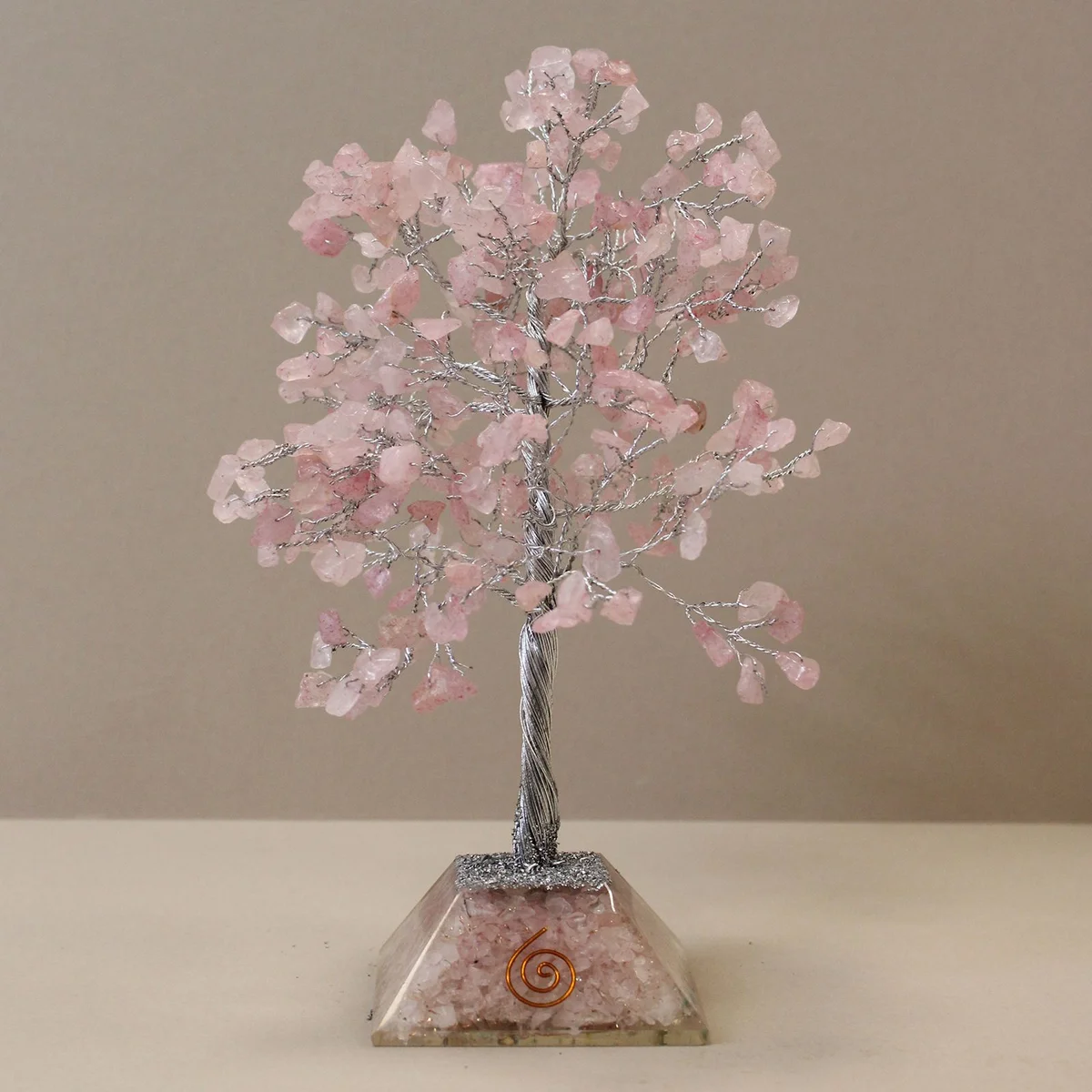 Rose quartz gemstone tree with 320 stones on an organite base displayed on a white background