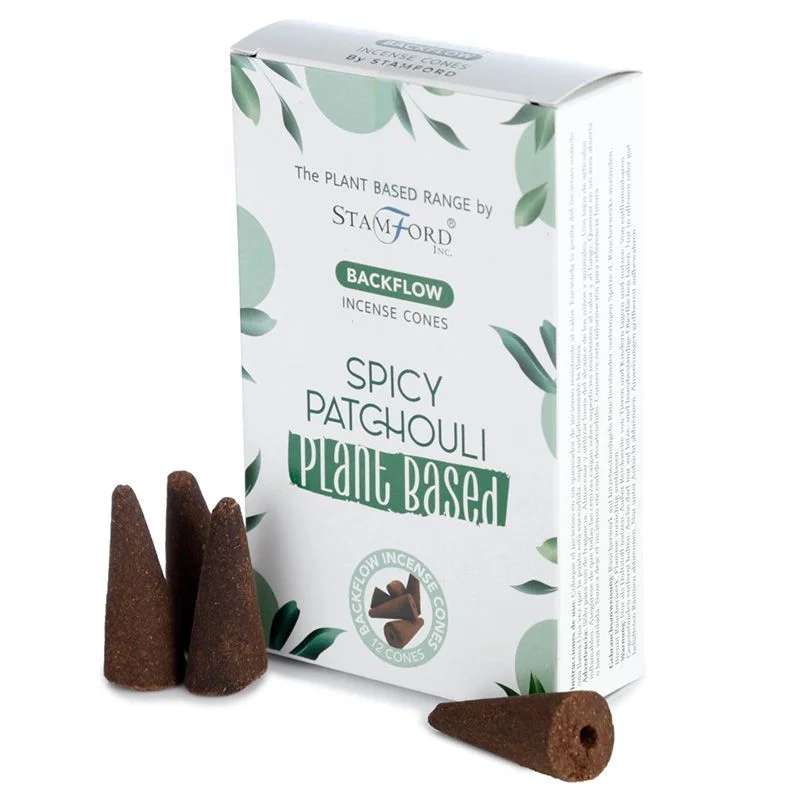Stack of spicy patchouli plant based backflow incense cones with smoke flowing downward on white background