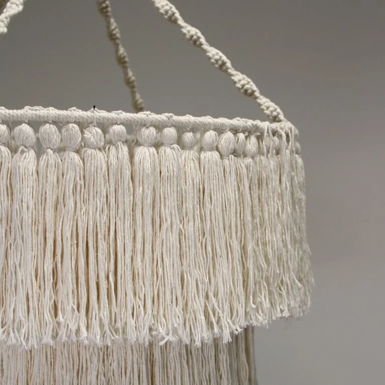 Natural macrame soft chandelier hanging from ceiling, featuring braided fabric strands, a boho wall hanging style.
