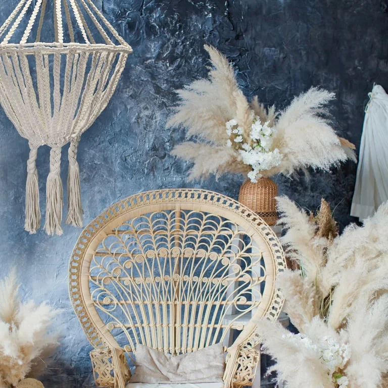 Large macrame drop chandelier hanging from ceiling, natural finish, multiple knot strands forming cascading shapes.