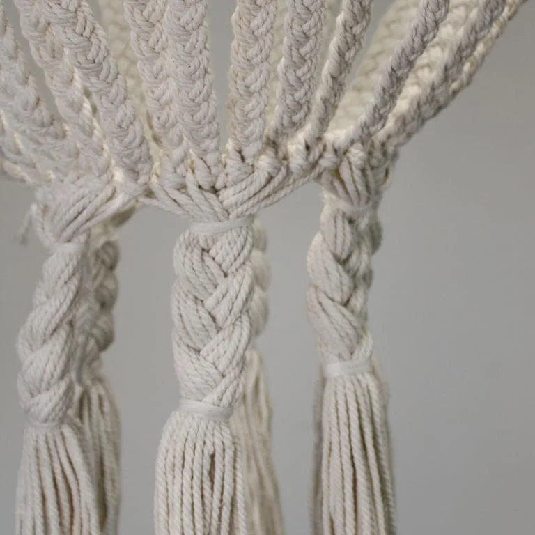 Large natural macrame chandelier hanging from ceiling, with winding rope drops, showcasing natural macrame decor.