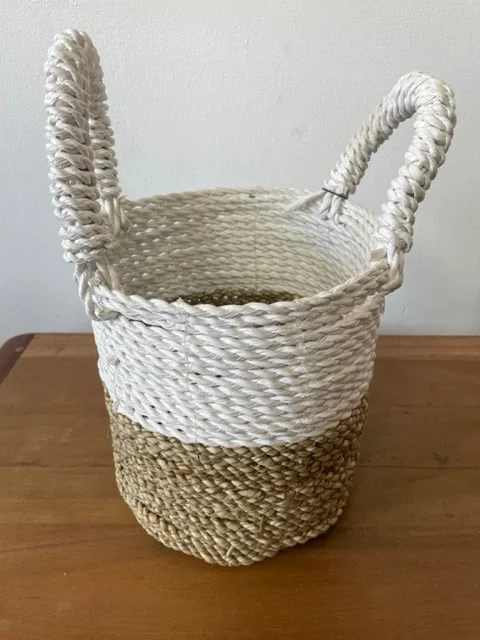 Set of natural white seagrass storage baskets neatly stacked.