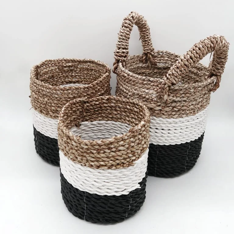 Dark grey seagrass basket paired with white and natural baskets, showcasing a rustic set.