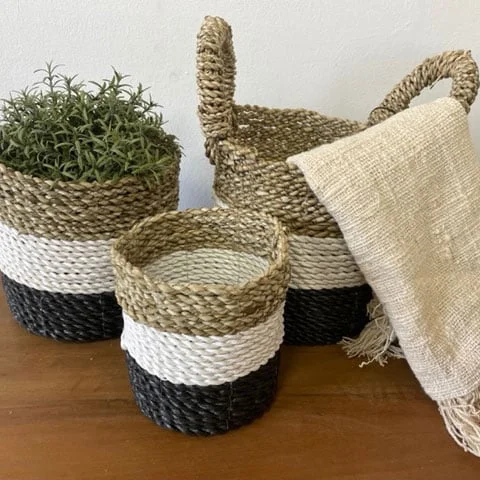 Woven storage baskets in dark grey, white, and natural seagrass tones displayed together