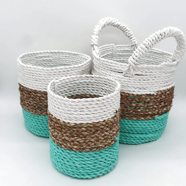A set of green seagrass baskets in natural and white tones, displayed together.