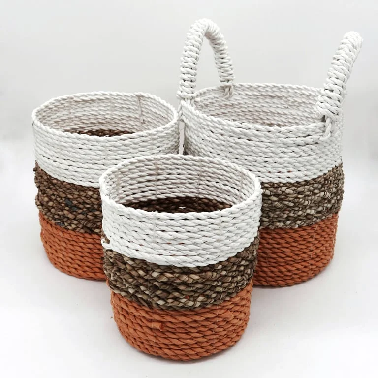 Stack of three seagrass natural storage baskets in orange, natural and white tones, ready for home décor.