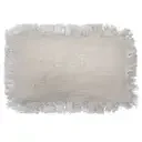 Linen cushion cover 30x50cm with fringe displayed folded, highlighting its texture.