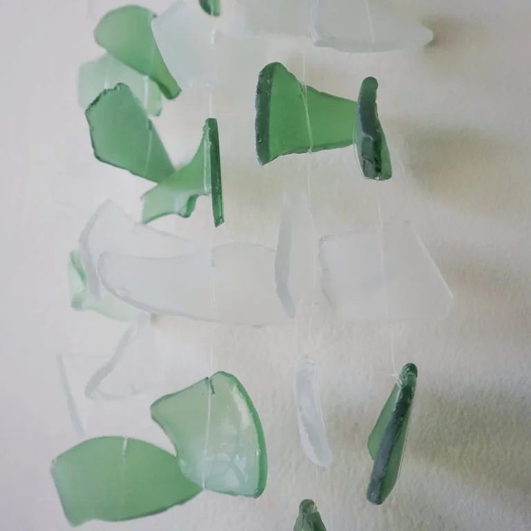 Drop-shaped green glass ornament with white details
