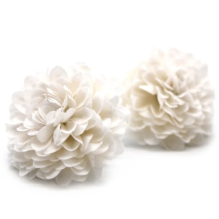 White craft soap shaped like a small chrysanthemum soap on a plain surface.