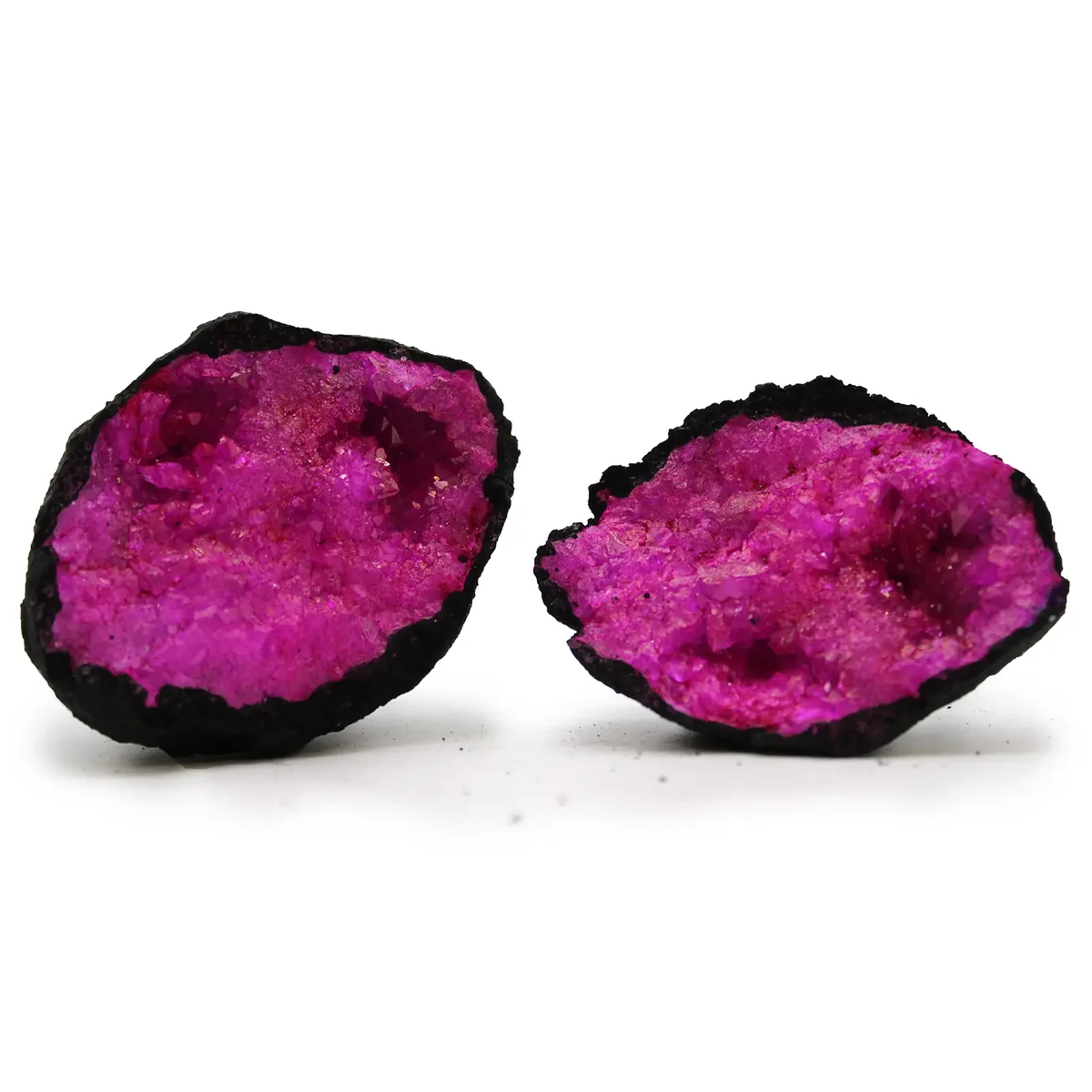 Dark red geodes with pink crystal interiors set against black rock background in a close-up view