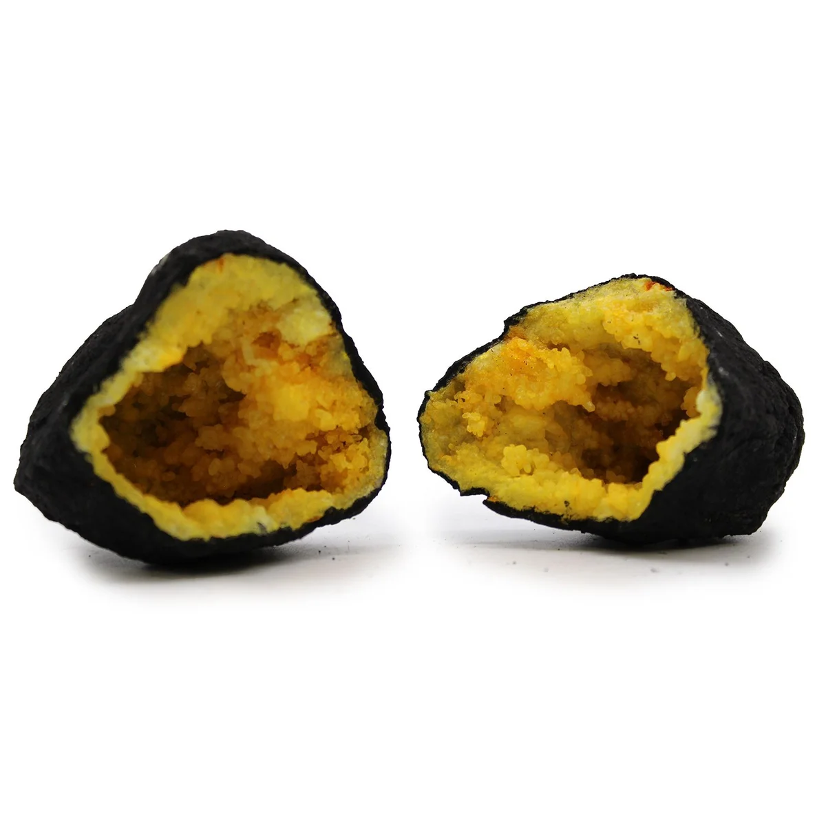 Yellow coloured calsite geodes displayed on black rock background