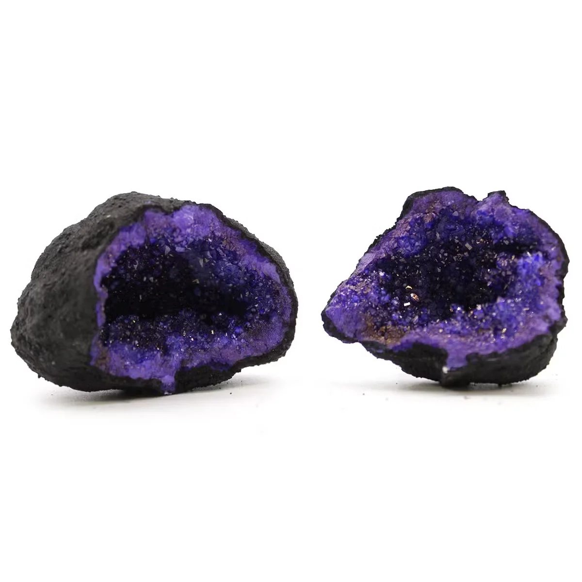 Turquoise and purple coloured calsite geodes on black rock, natural stone ornaments for decoration
