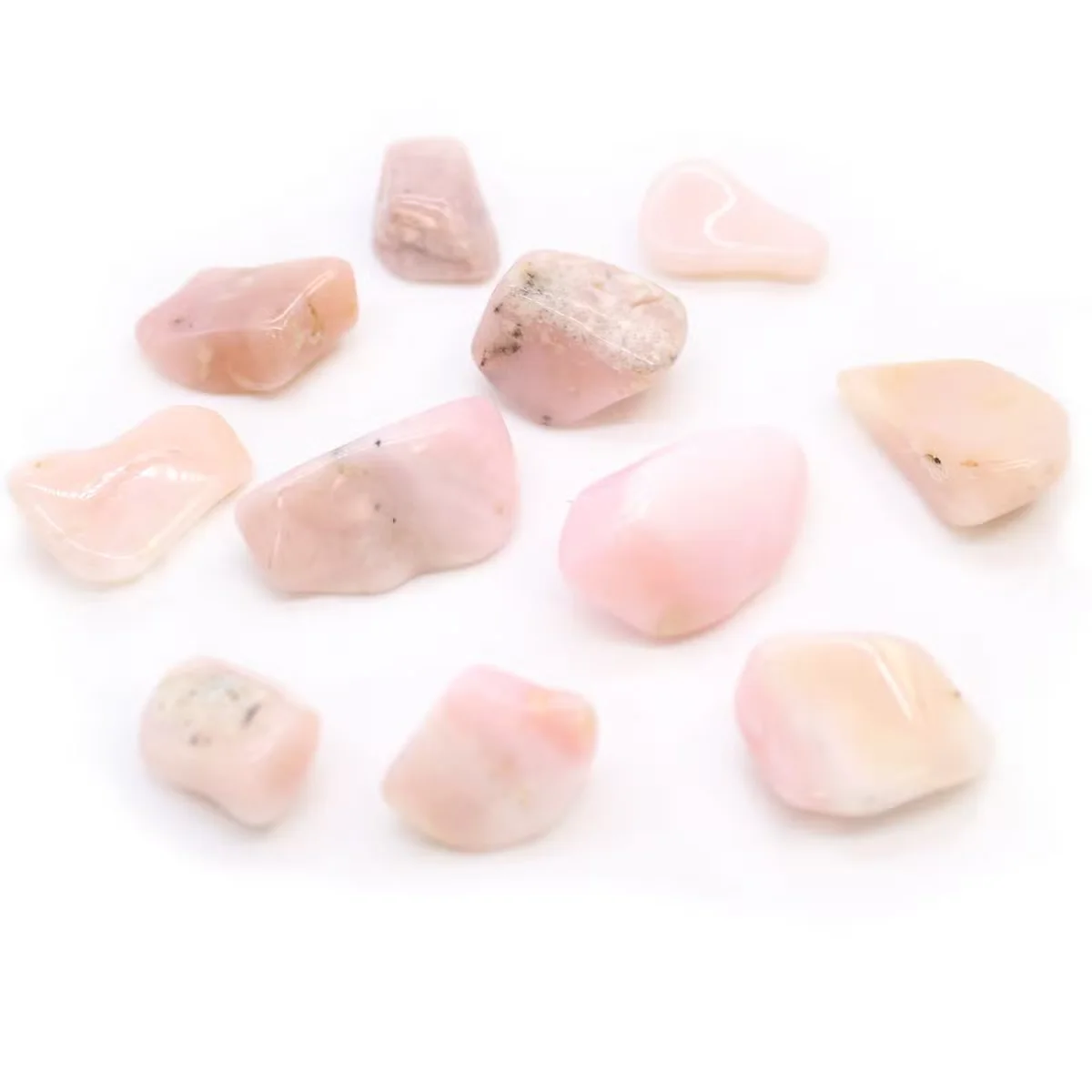 Smooth M tumble stone of Peruvian opal gemstone home ornament with soft blue and white hues on a white background