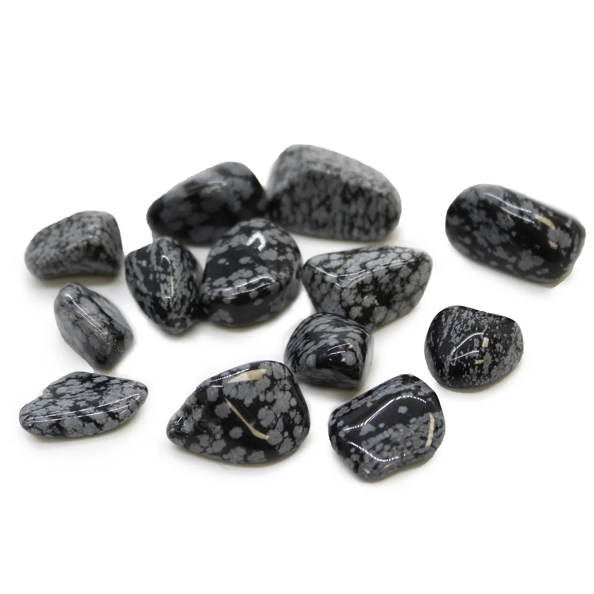 Polished snowflake obsidian stone showing black base with white snowflake-like patterns, smooth tumble shape