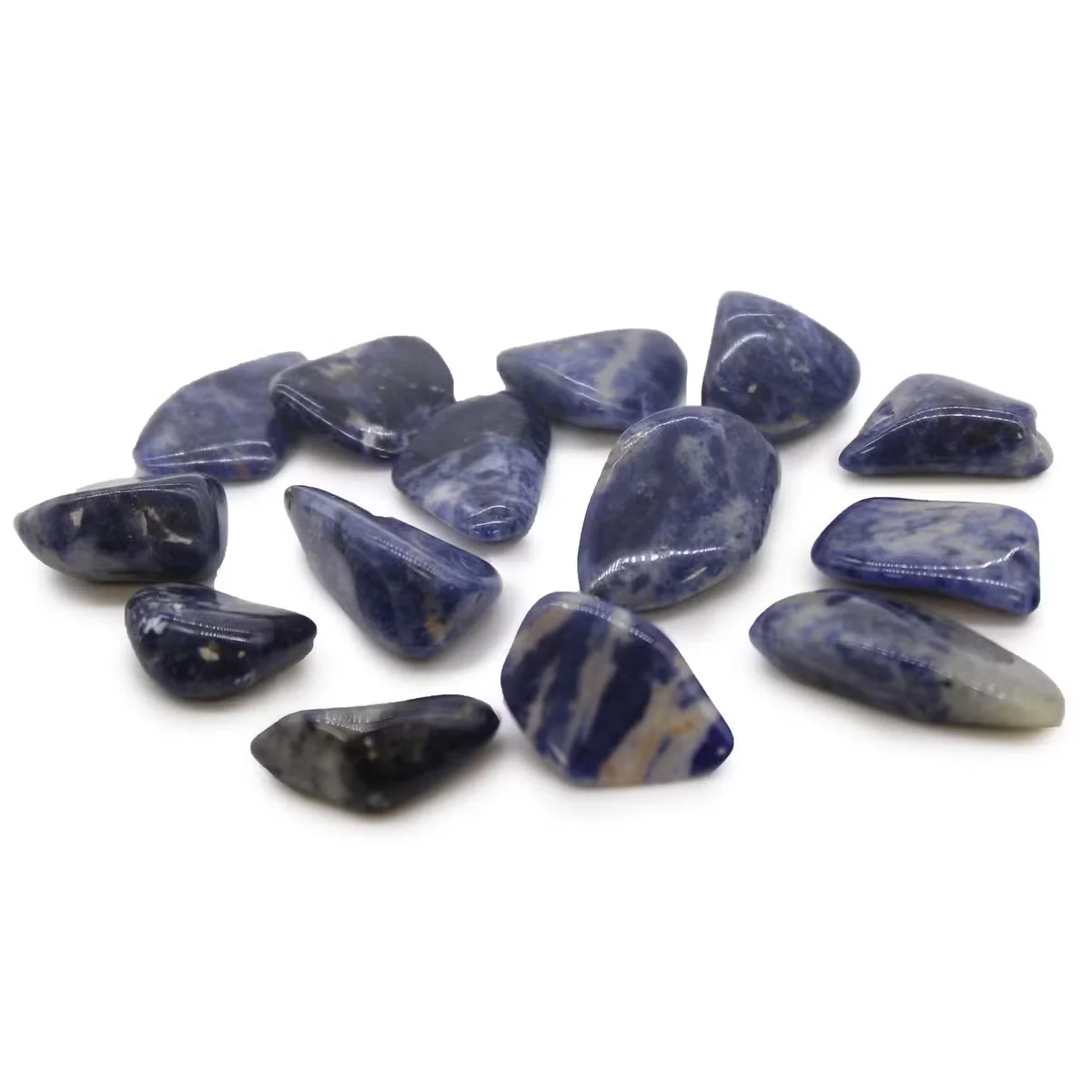 Polished M tumble stone sodalite crystal ornament with deep blue and white patterns on a white background