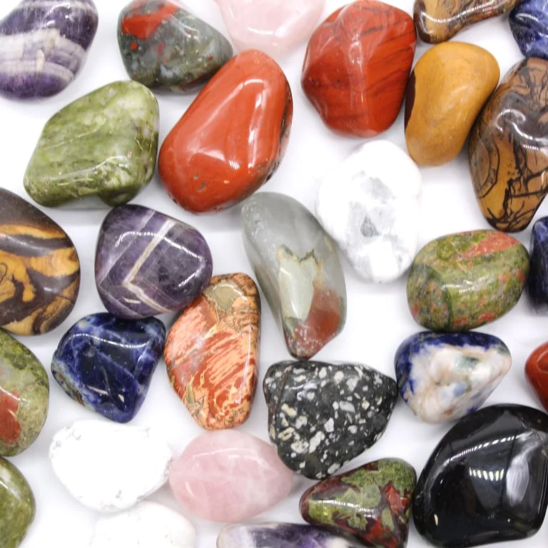 Medium-sized African rose quartz tumble stones on a wooden surface.