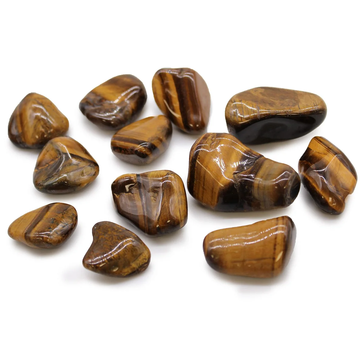 Medium golden tigers eye tumble stones with smooth polished surfaces, arranged closely together on a white background