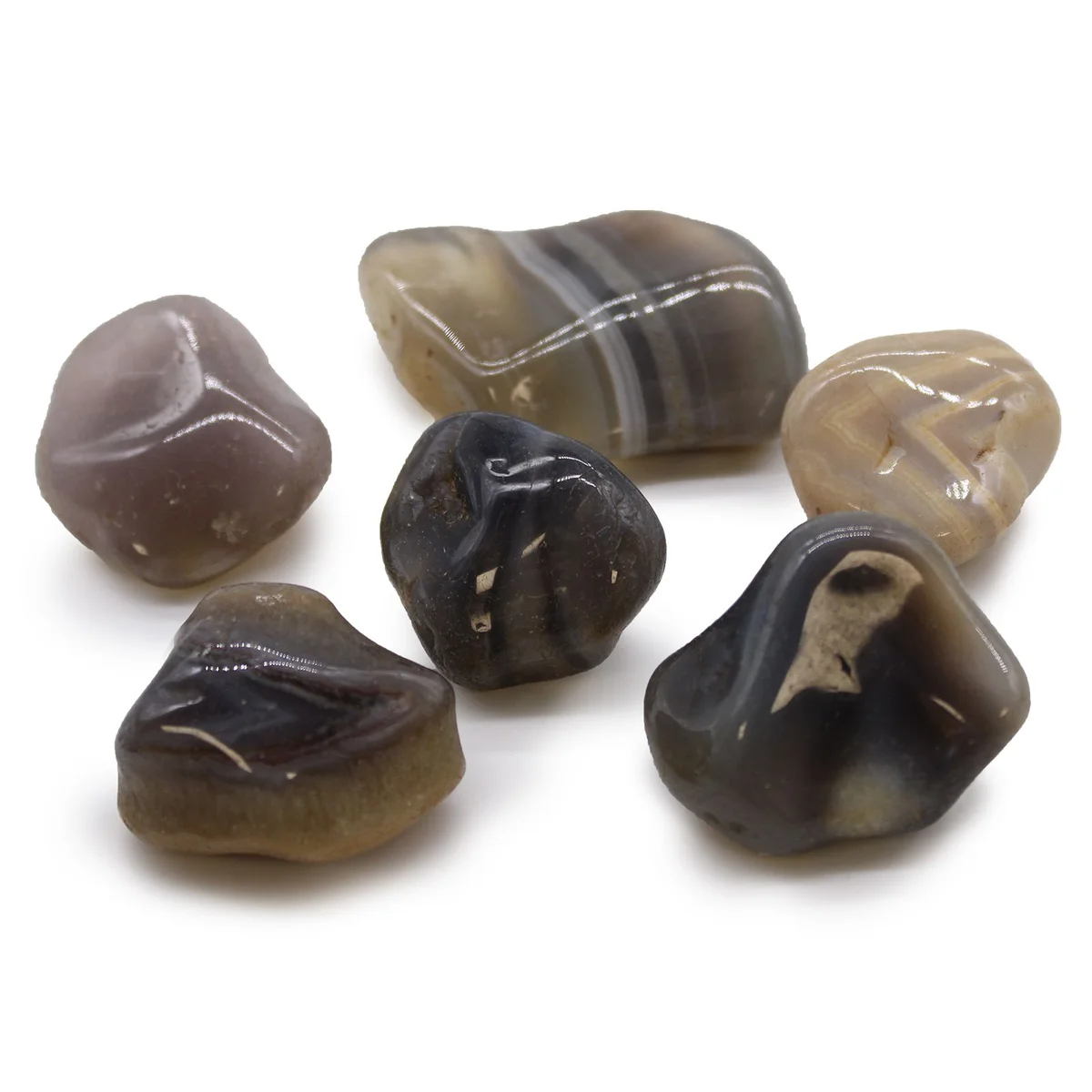 Large grey agate stones from Botswana, polished and tumbled, showing smooth surfaces and natural grey patterns