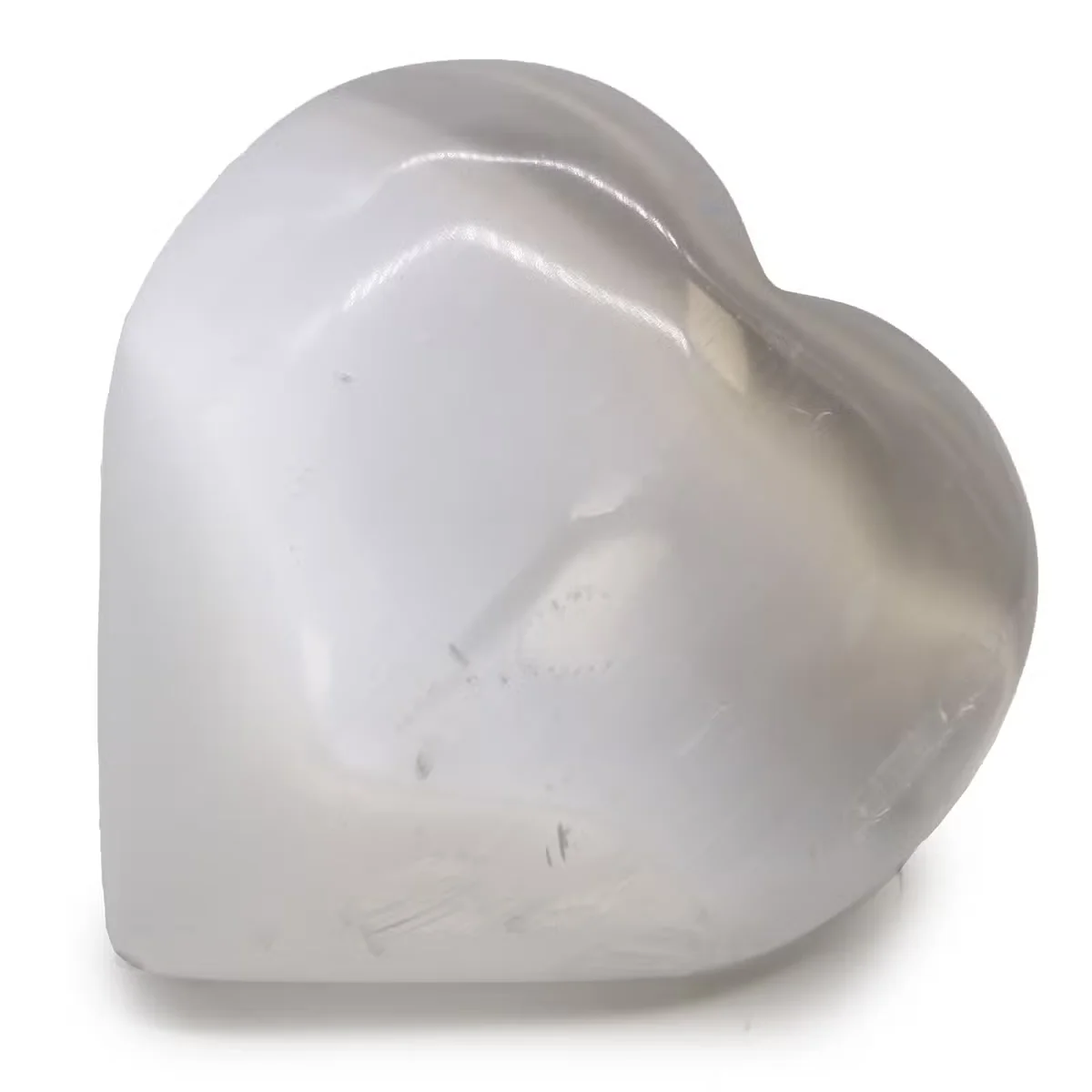Decorative selenite heart measuring 10 cm with smooth, translucent white crystal surface on a plain background