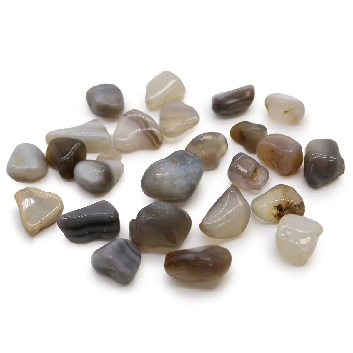 Small polished grey Botswana agate stones from Africa, smooth and rounded, displayed on a white background
