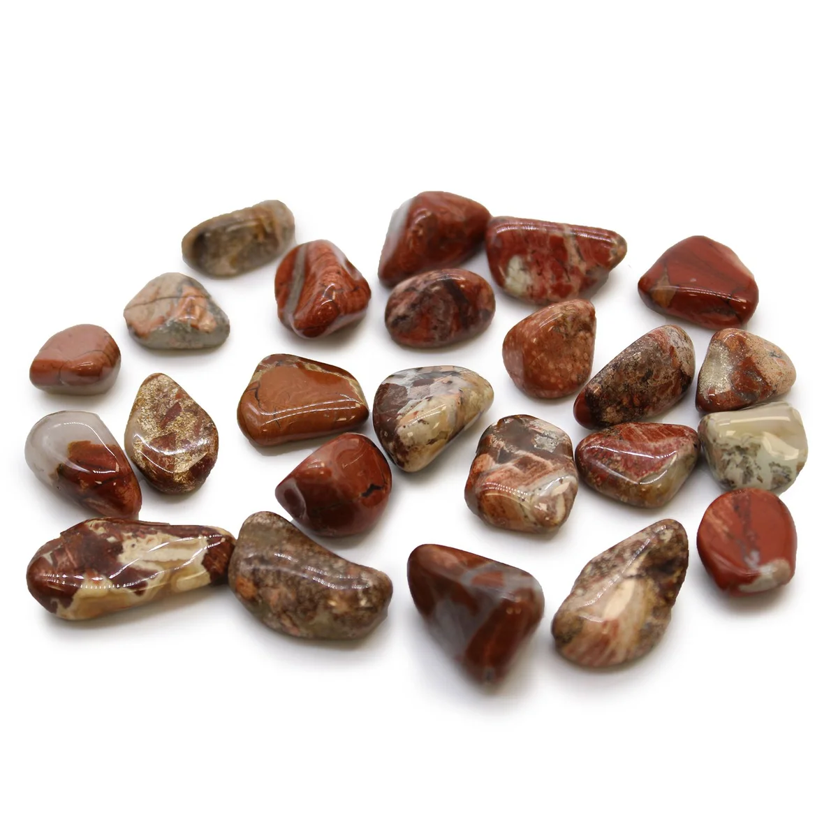 Small light jasper brecciated African tumble stones with smooth polished surfaces arranged on white background