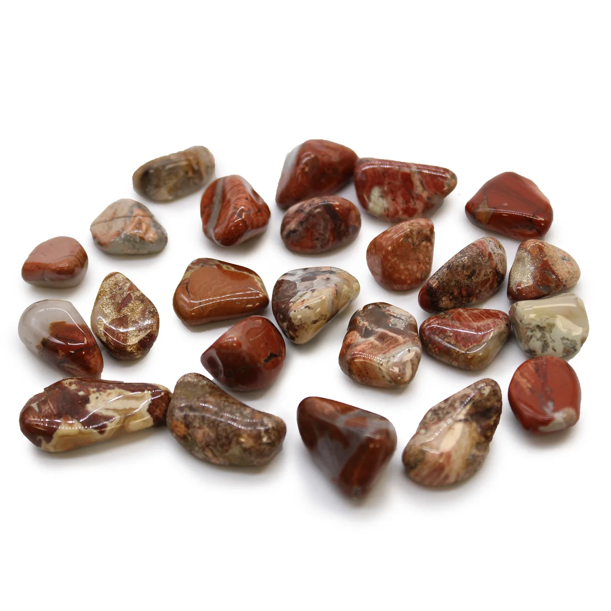 Collection of small light brecciated jasper stones with natural patterns on a white background