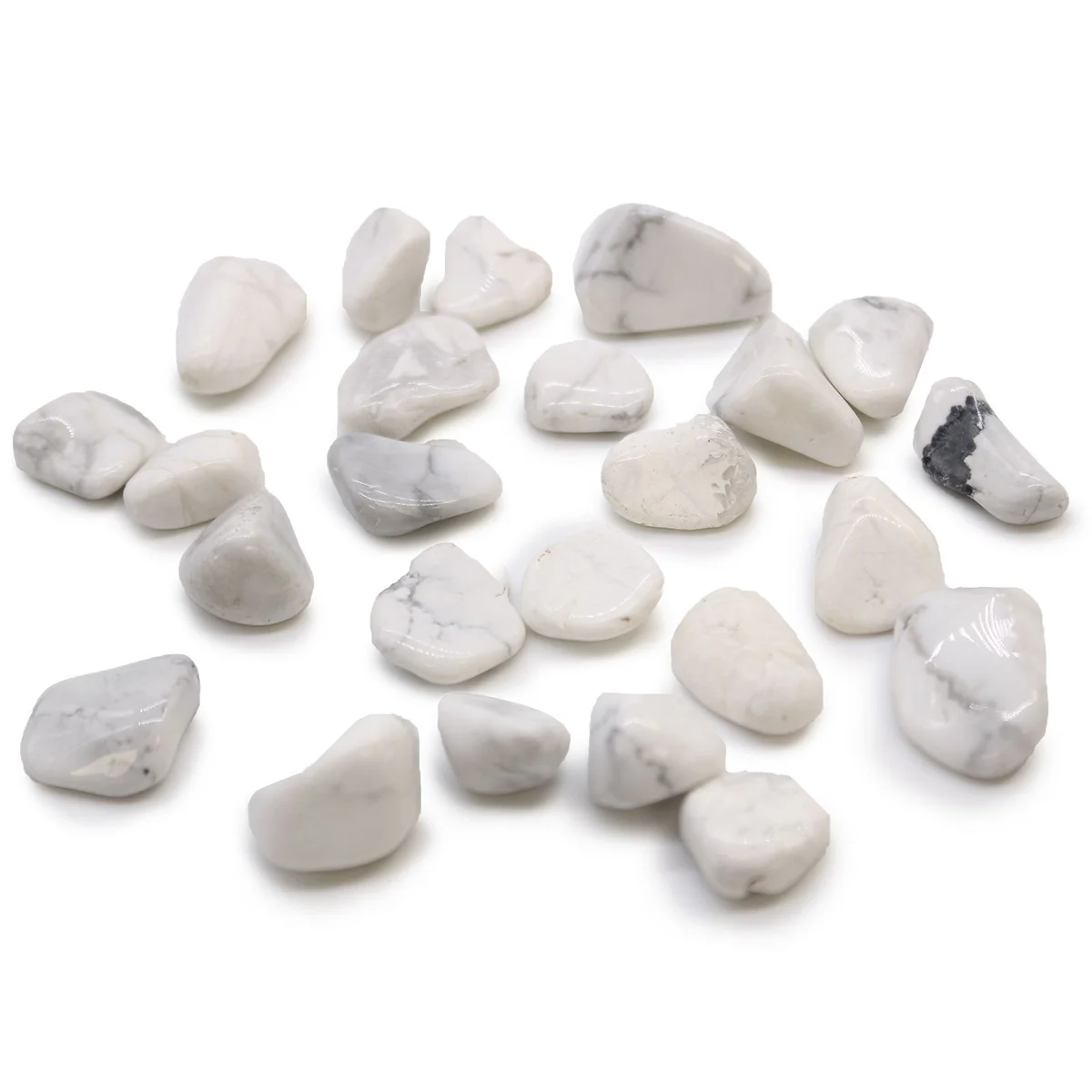 Small polished white howlite tumble stones with grey veining, smooth and rounded, displayed on a plain background