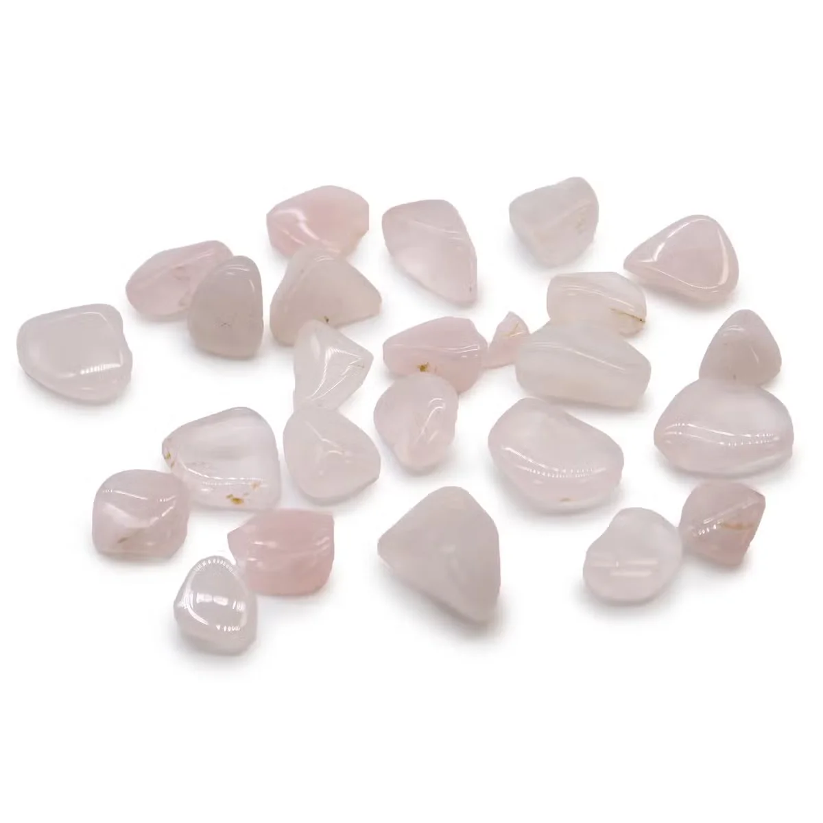Small decorative stones made of polished rose quartz in various soft pink shades, small African tumble stones set against white background