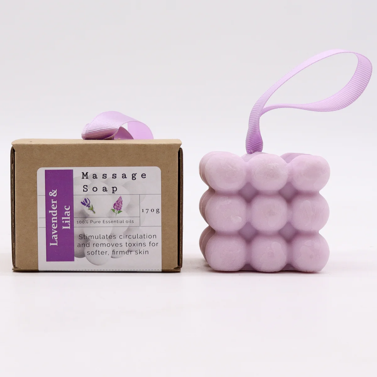 Box of single massage soaps in lavender and lilac hues, featuring a lilac soap with soft pastel packaging