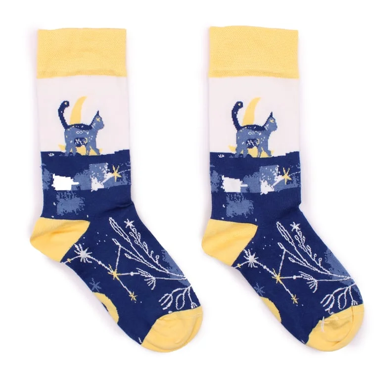 Pair of bamboo socks in Midnight Cat pattern, featuring bold feline motifs on dark navy fabric.
