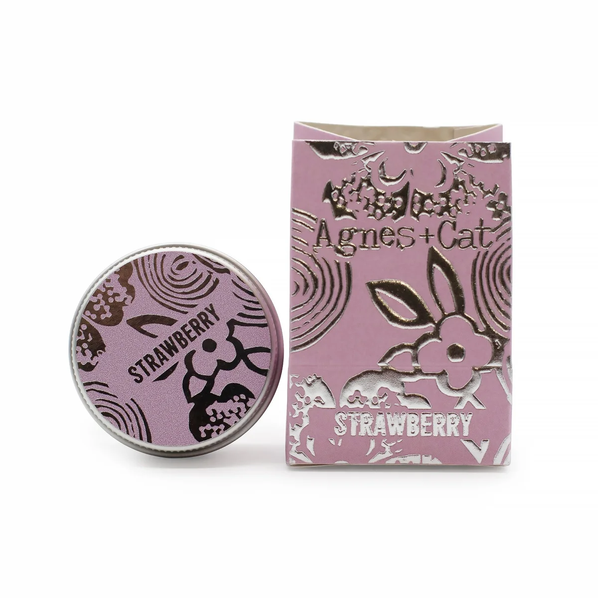 Strawberry lip balm tube with red cap and label featuring strawberries on white background