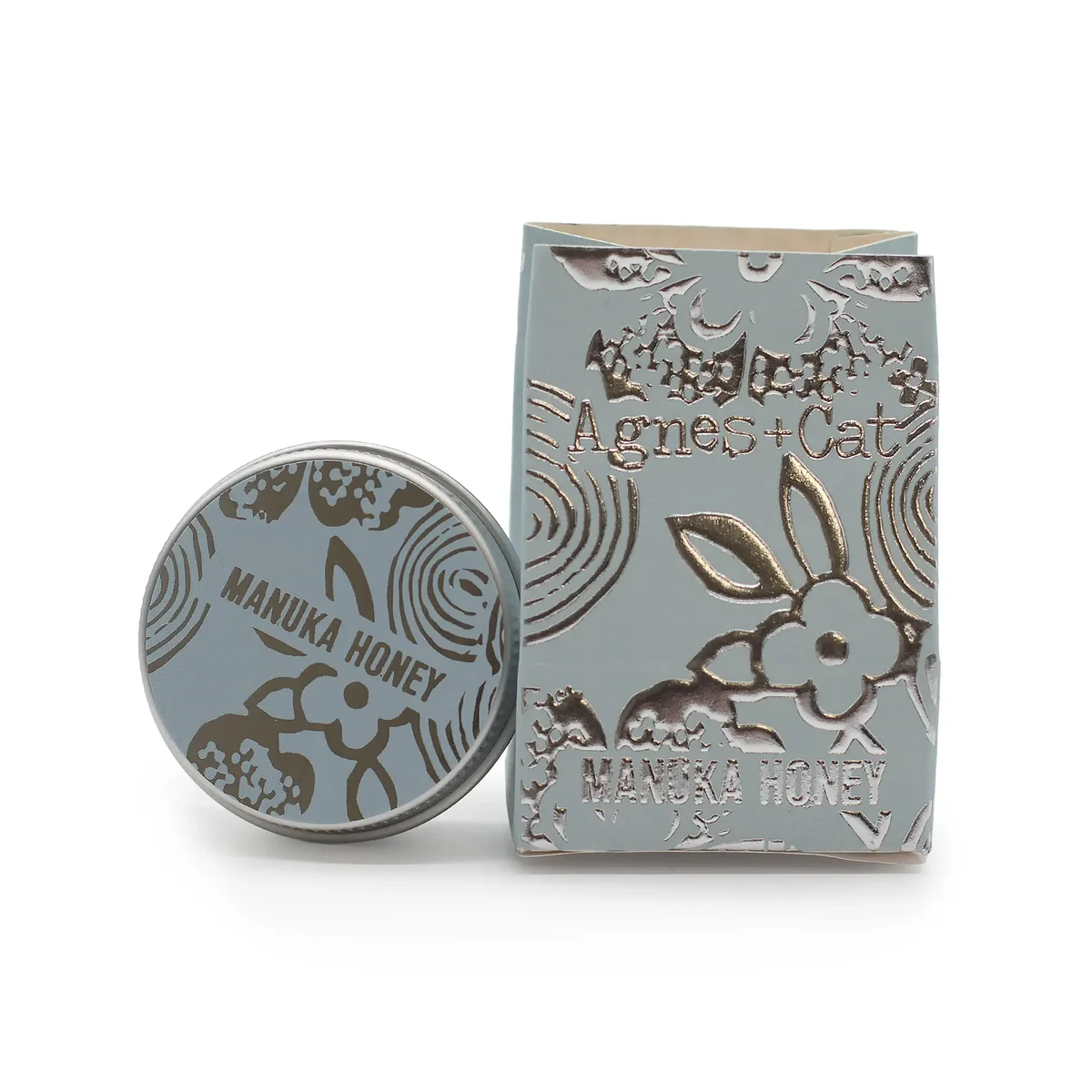 Tube of Agnes + Cat natural lip balm with Manuka Honey flavor on a white background