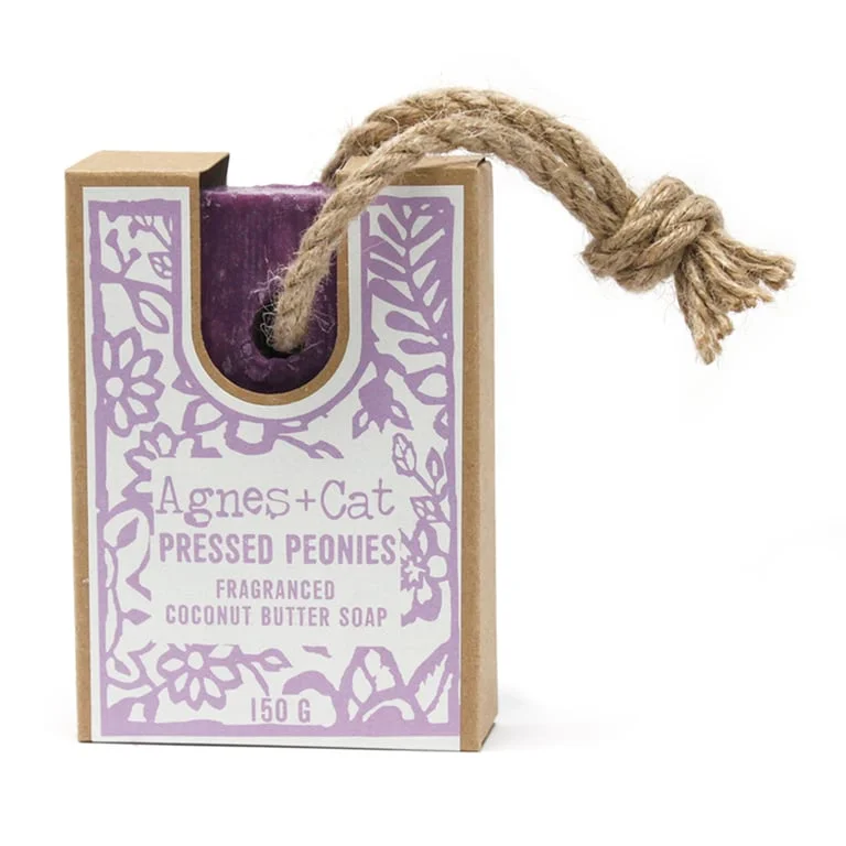 Pressed peonies soap hanging on a rope, showcasing dried peony flowers embedded in clear soap.