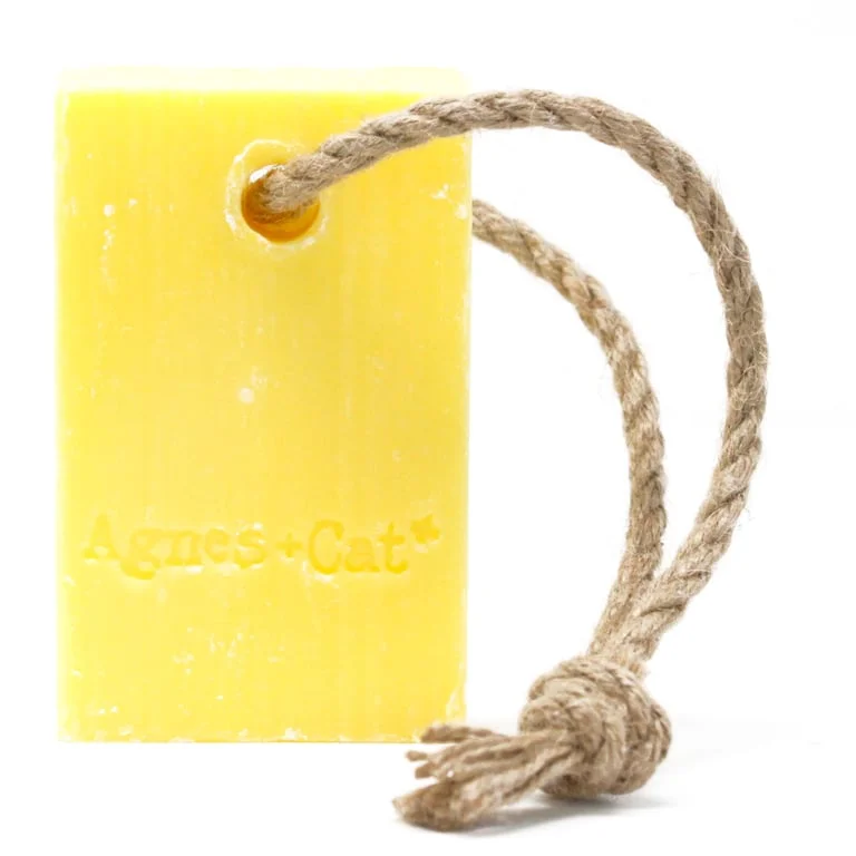 Fresh citrus soap hanging on a rope, displayed as a bright bar ready for use.