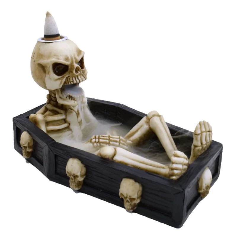 Skeleton in coffin-shaped backflow incense burner with smoke flowing down, coffin incense holder design in dark tones
