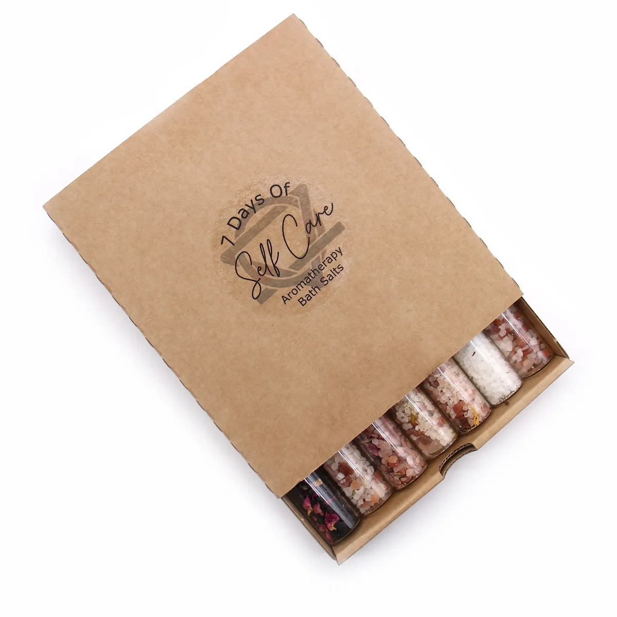 A gift pack of seven glass vials containing bath salts in vials, displayed on a wooden surface.