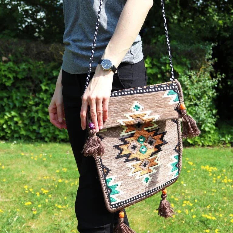 Pale grey Kilim messenger bag shown from side with open flap, tote style, suitable for festivals