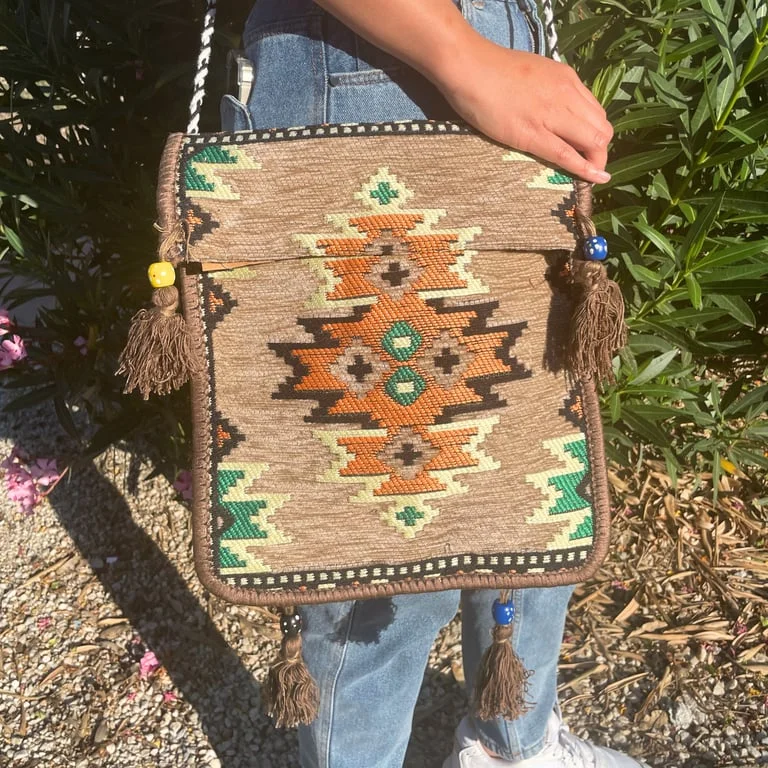 Beige Kilim festival messenger bag with woven pattern on canvas, open front and long strap.