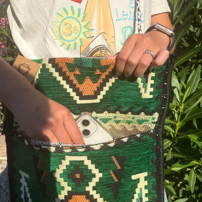 Emerald green messenger bag featuring a Kilim pattern.