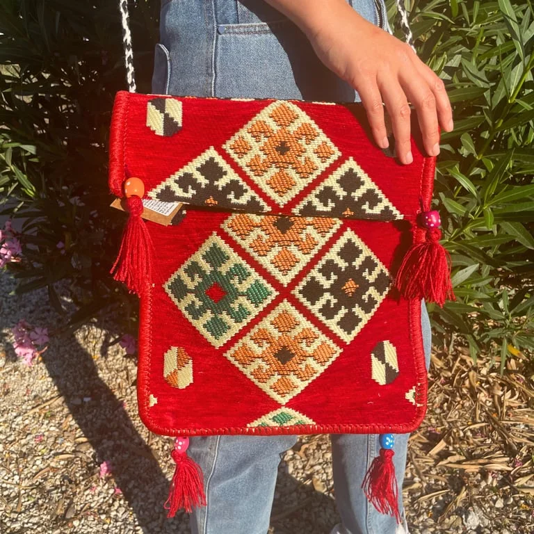 Red Kilim festival messenger bag displayed with strap, featuring woven pattern.