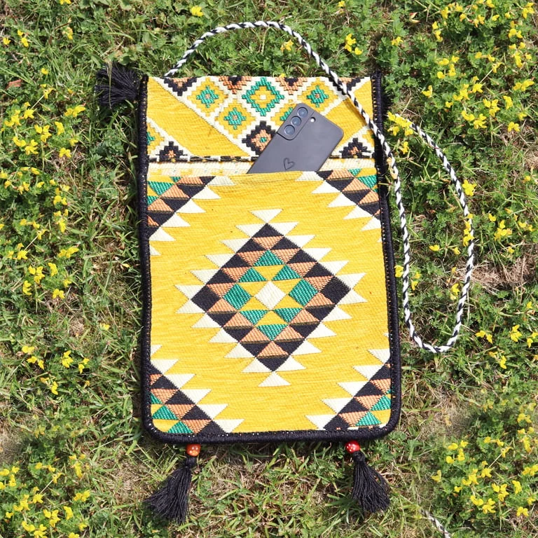 Yellow kilim messenger bag with woven pattern and strap, shown upright.