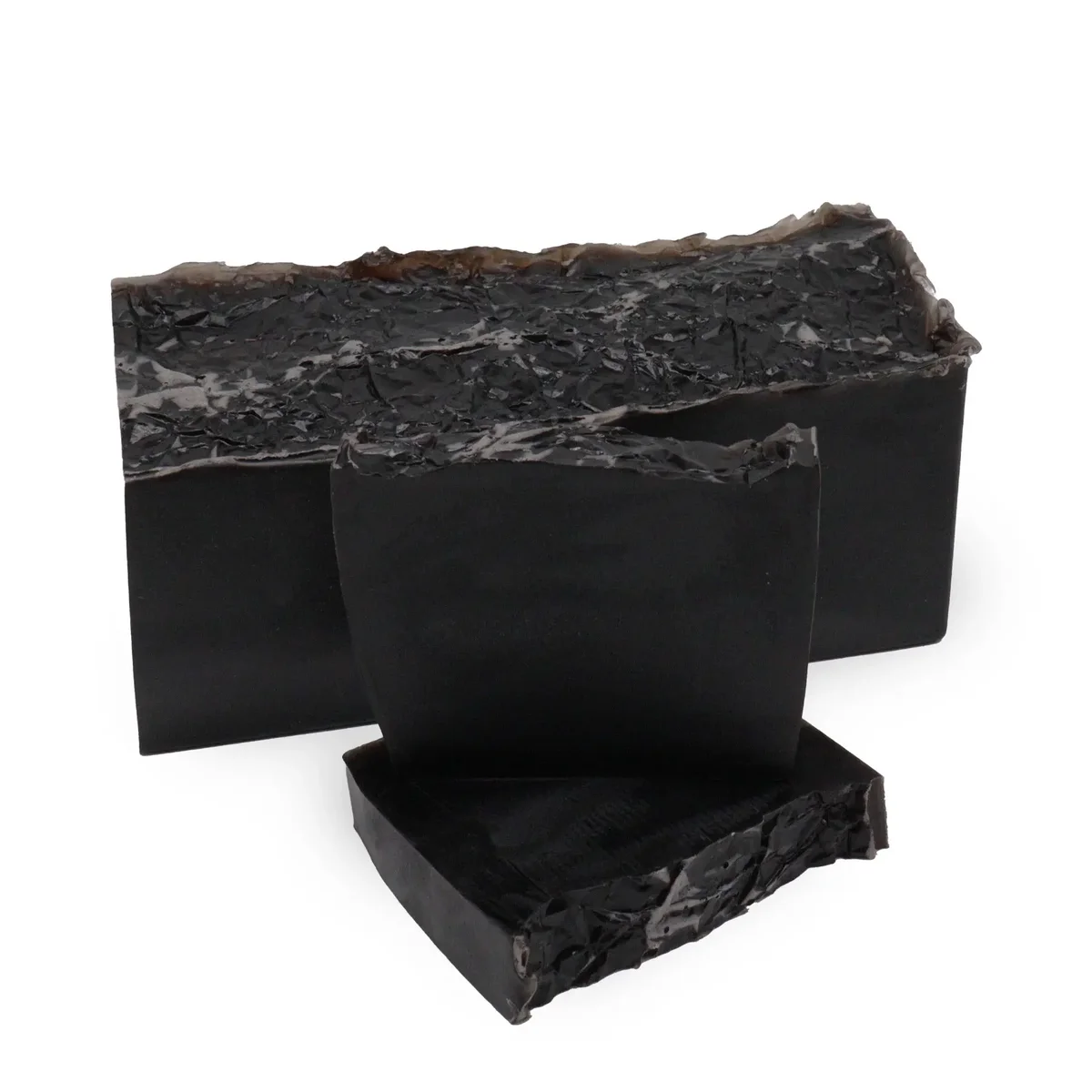 Black soap loaf labeled Harmony Noir with smooth dark surface on a white background