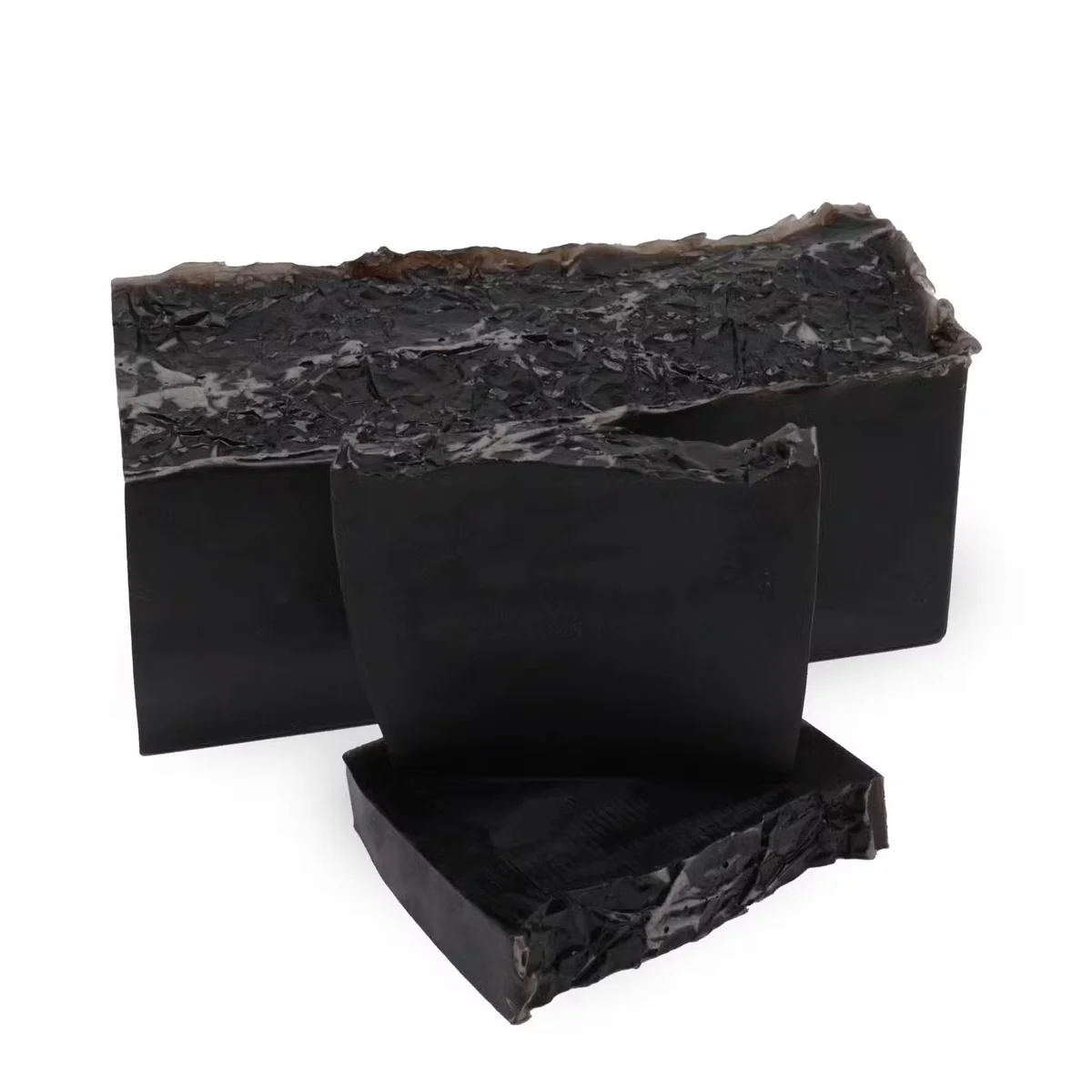 Large soap loaf of Harmony Noir with smooth black surface and rectangular shape on a plain background