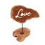 Love candle holder sign with bold lettering and a stylised flame symbol on its frame.