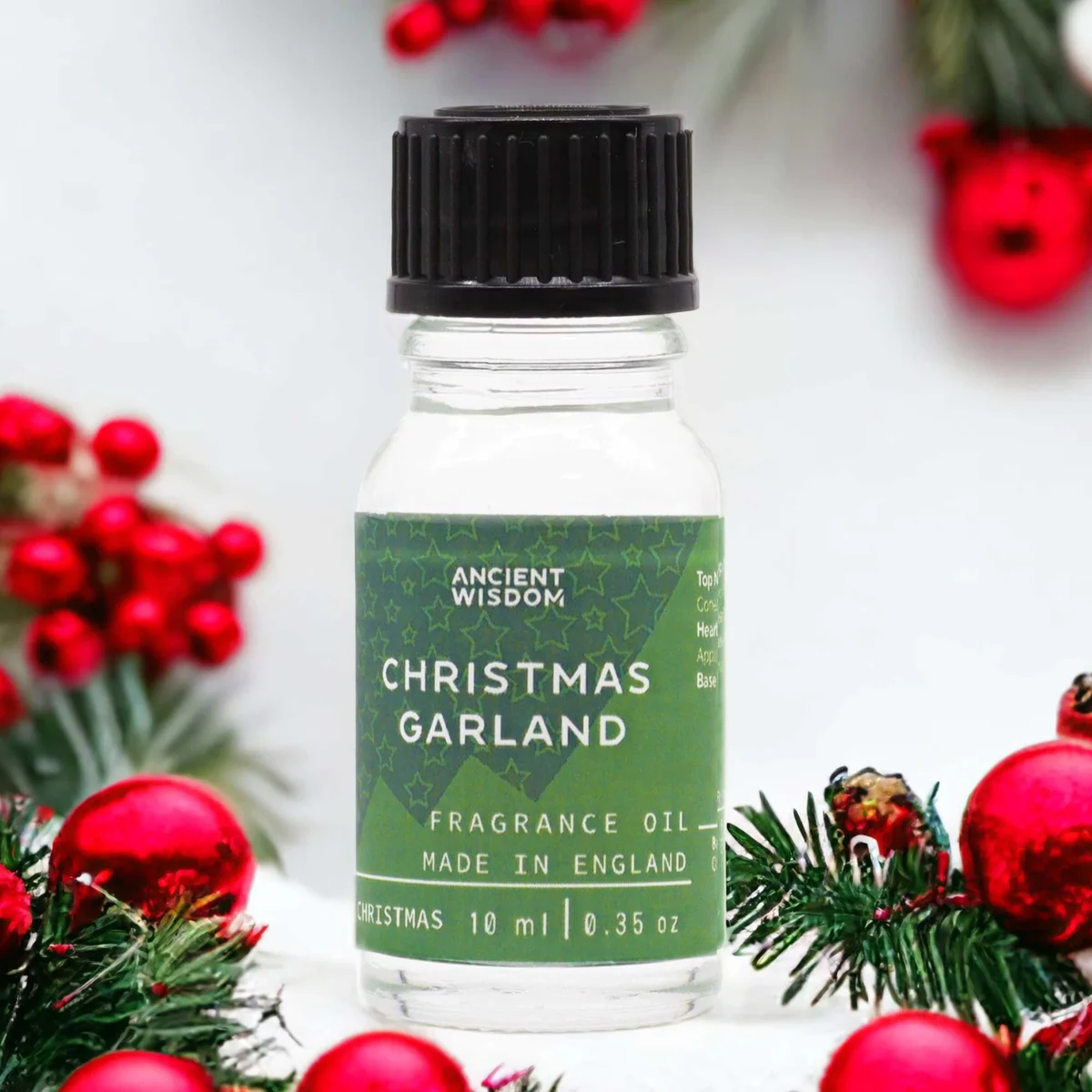 Small 10ml bottle of Christmas fragrance oil labeled Christmas Garland Fragrance Oil on white background